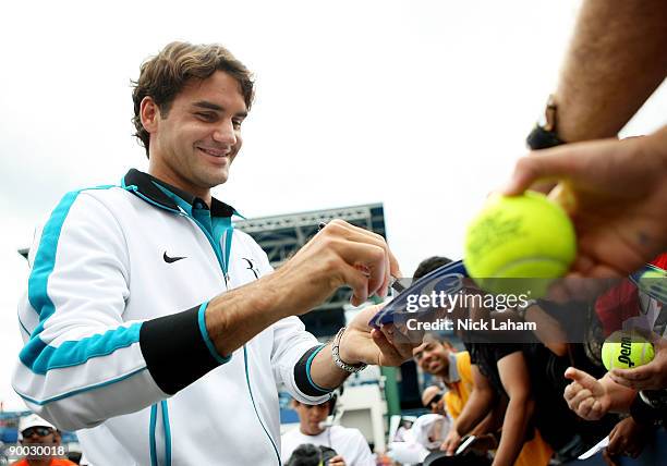 Roger Federer of Switzerland signs autographs for fans after defeating Novak Djokovic of Serbia in the Singles Final during day seven of the Western...