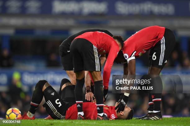 Manchester United's Argentinian defender Marcos Rojo receives medical attention during the English Premier League football match between Everton and...