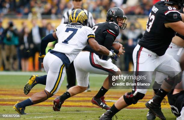 Quarterback Jake Bentley of the South Carolina Gamecocks is sacked by defensive back Khaleke Hudson of the Michigan Wolverines during the first...