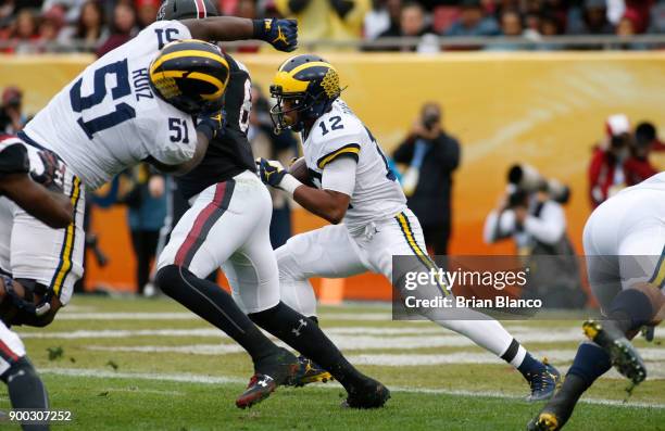 Running back Chris Evans of the Michigan Wolverines runs the ball during the first quarter of the Outback Bowl NCAA college football game against the...