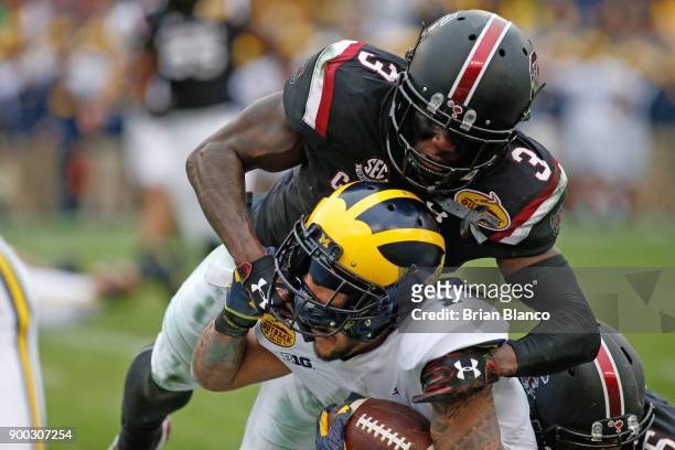 Defensive back Chris Lammons of the South Carolina Gamecocks tackles wide receiver Kekoa Crawford of the Michigan Wolverines during a carry in the...
