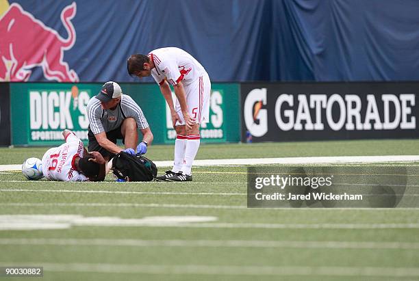 Dane Richards of the New York Red Bulls lies on the field with leg cramps as teammate Albert Celades looks on during the game against FC Dallas on...