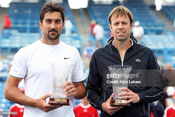 Nenad Zimonjic of Serbia and Daniel Nestor of Canada hold their trophies after defeating Bob Bryan and Mike Bryan in the Doubles Final during day...