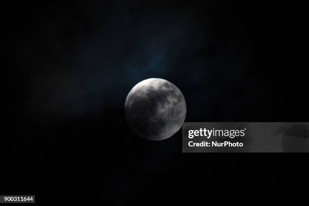 The 'supermoon' is pictured rising over London on January 1, 2018. Supermoons happen when a full moon approximately coincides with the moon's...