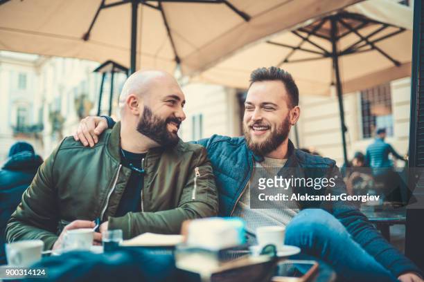 två leende vänner dricka kaffe och prata i coffee shop - couple laughing hugging bildbanksfoton och bilder