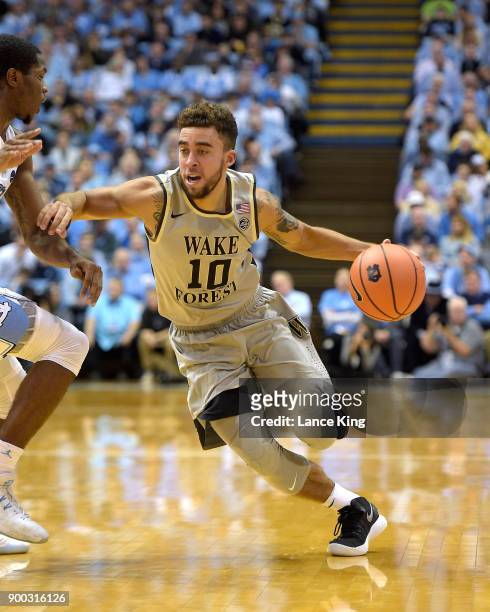 Mitchell Wilbekin of the Wake Forest Demon Deacons drives against the North Carolina Tar Heels at Dean Smith Center on December 30, 2017 in Chapel...