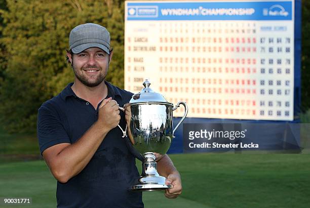 Ryan Moore poses with the winner's trophy after winning the Wyndham Championship in a sudden death playoff against Kevin Stadler and Jason Bohn at...