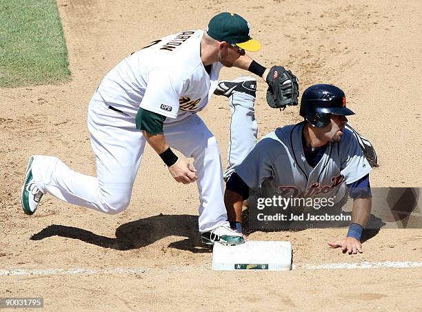 Alex Avila of the Detroit Tigers is picked off at first by Daric Barton of the Oakland Athletics during a Major League Baseball game on August 23,...