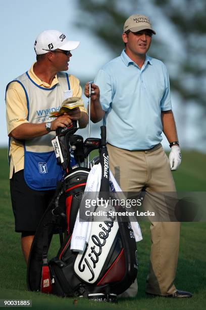 Jason Bohn pulls a club with his caddie on the 18th hole during the final round of the Wyndham Championship at Sedgefield Country Club on August 23,...