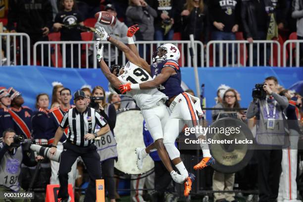 Mike Hughes of the UCF Knights and Darius Slayton of the Auburn Tigers battle for the ball in the first half during the Chick-fil-A Peach Bowl at...