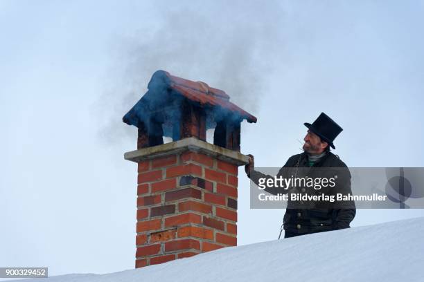 chimney sweeper in winter on a roof with smoky chimney, upper bavaria, bavaria, germany - schornsteinfeger stock-fotos und bilder