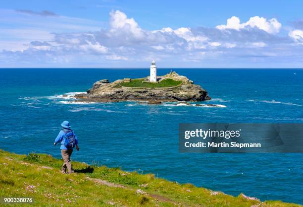 woman hikes on coastal route at godrevy point, godrevy lighthouse on godrevy island, near gwithian, cornwall, england, great britain - gwithian foto e immagini stock