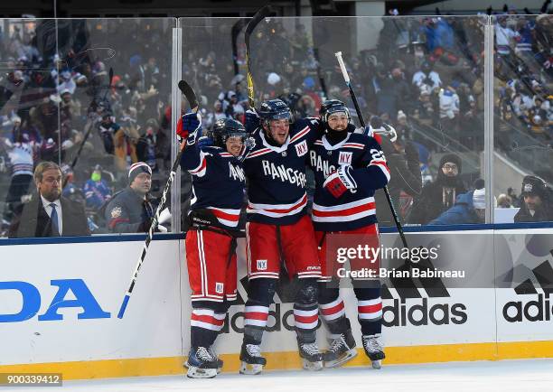 Mats Zuccarello, J.T. Miller and Kevin Shattenkirk of the New York Rangers celebrate near the side boards after Miller scored the game-winning goal...