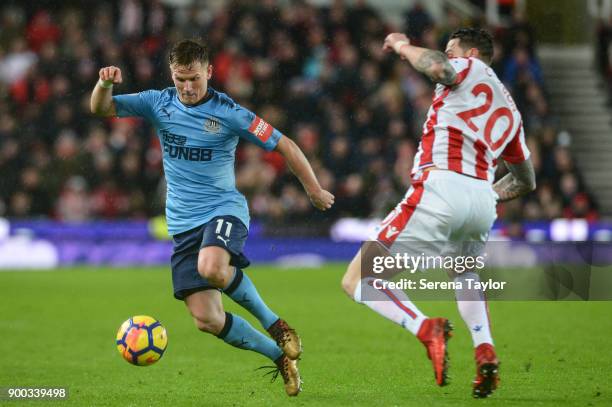 Matt Ritchie of Newcastle United looks to control the ball whilst being challenged by Geoff Cameron of Stoke City during the Premier League match...