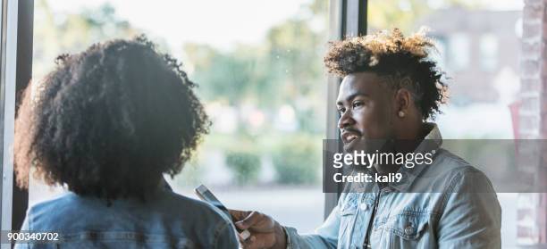 young mixed race couple in coffee shop - curly hair back stock pictures, royalty-free photos & images