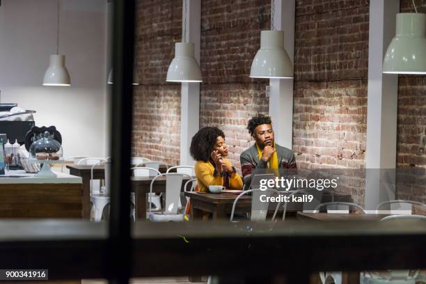 young adults sitting in coffee shop working - on the outside looking in stock pictures, royalty-free photos & images