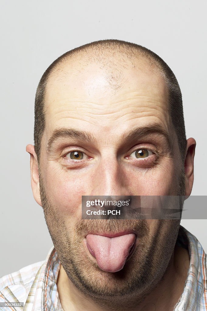 Bald man sticking out his tongue