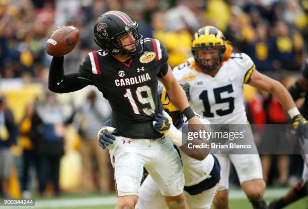 Quarterback Jake Bentley of the South Carolina Gamecocks looks for a receiver while getting pressure from defensive lineman Maurice Hurst of the...