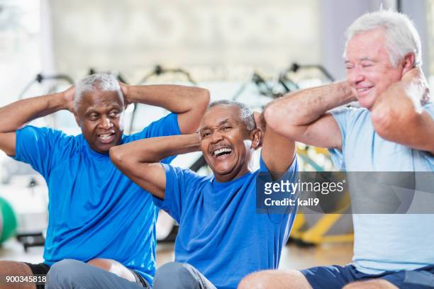 three multi-ethnic senior men in gym exercising - fitness ball stock pictures, royalty-free photos & images