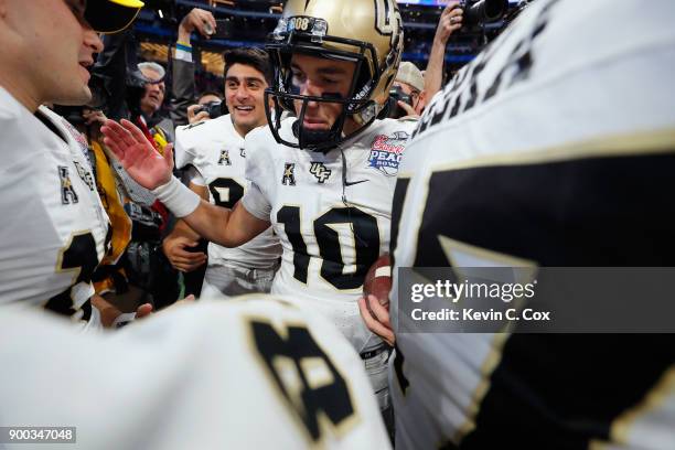 McKenzie Milton of the UCF Knights celebrates with teammates after defeating the Auburn Tigers 34-27 to win the Chick-fil-A Peach Bowl at...