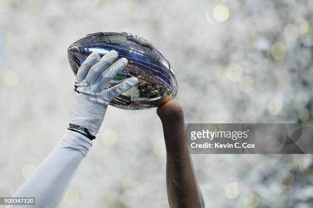 Shaquem Griffin of the UCF Knights holds the trophy after defeating the Auburn Tigers 34-27 to win the Chick-fil-A Peach Bowl at Mercedes-Benz...