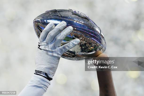 Shaquem Griffin of the UCF Knights holds the trophy after defeating the Auburn Tigers 34-27 to win the Chick-fil-A Peach Bowl at Mercedes-Benz...