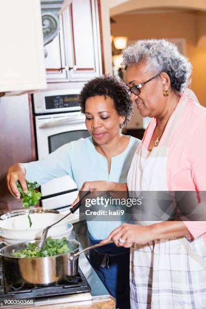 african-american women cooking collard greens on stove - southern food stock pictures, royalty-free photos & images