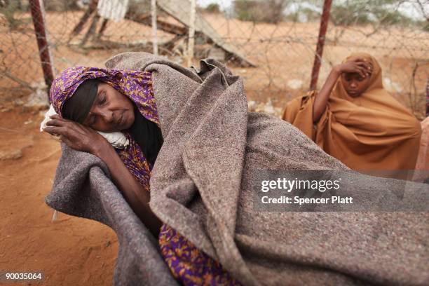 Batola Khalil Mohamed who is sick, rests in a wheelbarrow after making a three day journey from Somalia with members of her family August 24, 2008 at...