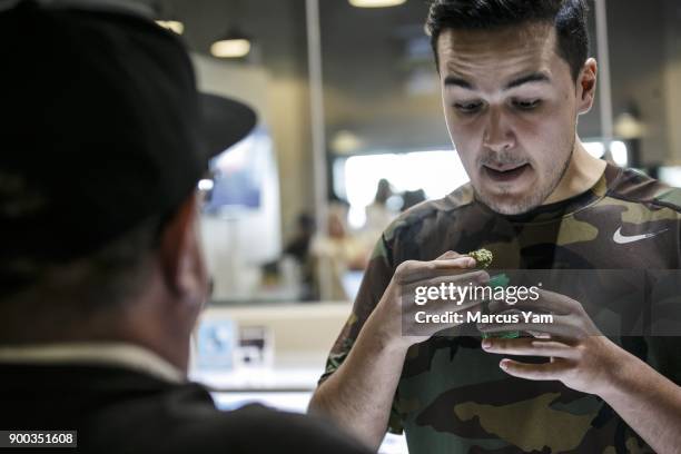 Jason Ayala, from New York reacts to an inspection of a product offered at 420 Central on the first official day of legal recreational pot sales in...