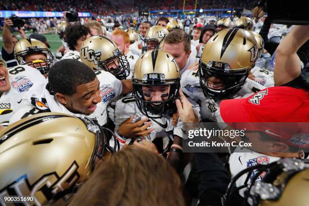 McKenzie Milton of the UCF Knights celebrates with teammates after defeating the Auburn Tigers 34-27 to win the Chick-fil-A Peach Bowl at...