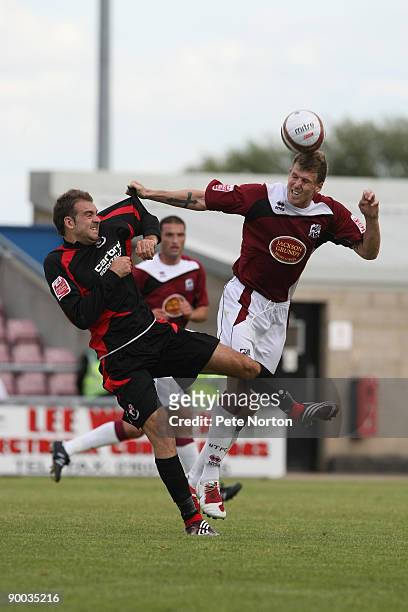 Dean Beckwith of NorthamptonTown heads the ball as he tussles with Brett Pitman of AFC Bournemouth during the Coca Cola League Two Match between...