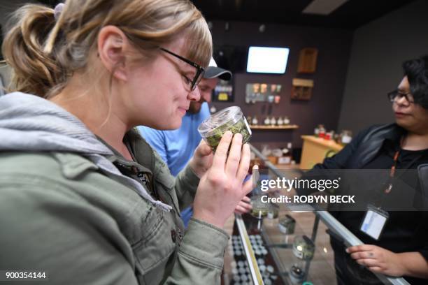 Tourist Laura Torgerson, visiting from Arizona, smells cannabis buds at the Green Pearl Organics dispensary on the first day of legal recreational...