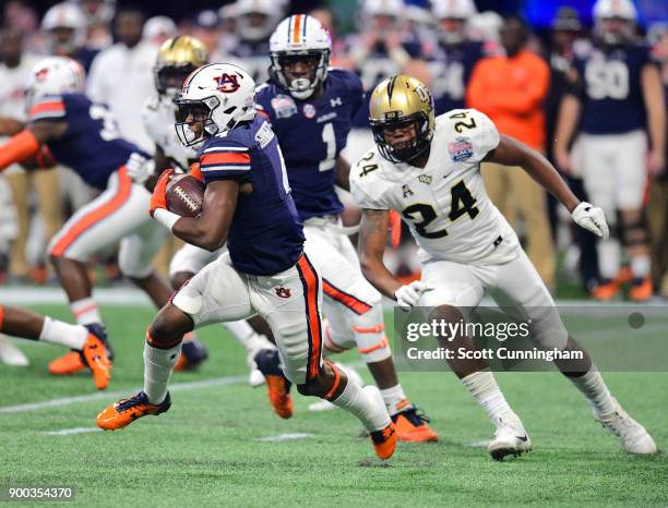 Noah Igbinoghene of the Auburn Tigers carries the ball against the Central Florida Knights during the Chick-fil-A Peach Bowl on January 1, 2018 in...