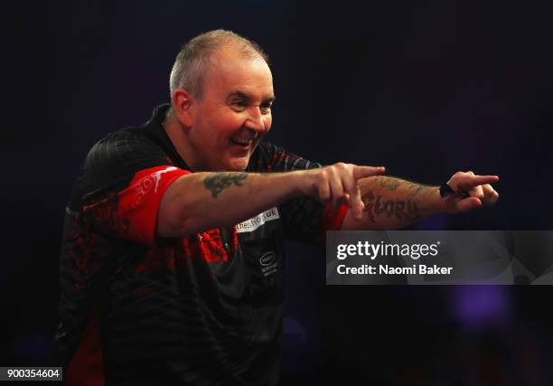 Phil Taylor of England celebrates after scoring 180 during the PDC World Darts Championship final against Rob Cross of England on Day Fifteen at the...