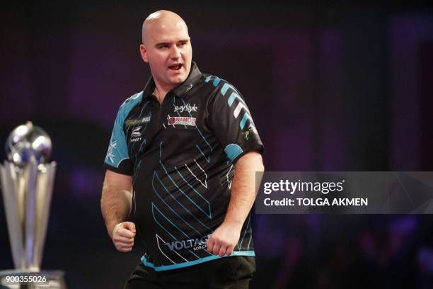 English professional darts player, Rob Cross reacts as he competes against English professional darts player, Phil Taylor at the PDC World Darts...