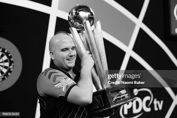 Rob Cross of England poses with the Sid Waddell Trophy after winning the PDC World Darts Championship final against Phil Taylor of England on Day...