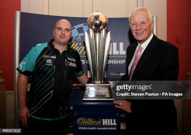 Rob Cross and Barry Hearn chairman of PDC poses with the trophy during day fifteen of the William Hill World Darts Championship at Alexandra Palace,...