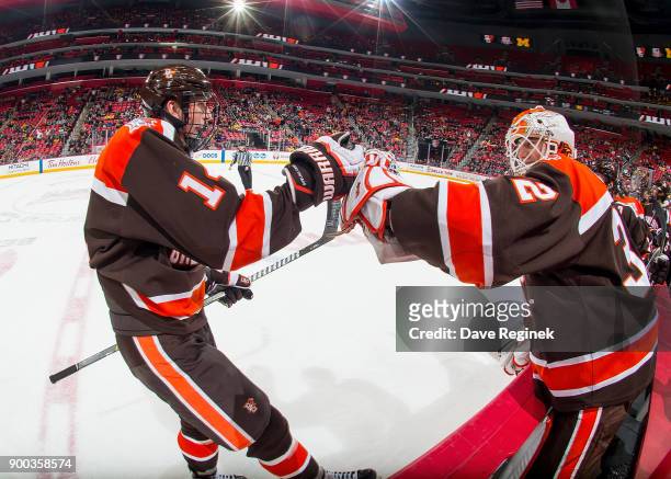 Justin Wells of the Bowling Green Falcons pounds gloves with teammate Brett Rich after his first period goal against the Michigan Wolverines during...