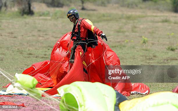 Sri Lankan army commando untangles from a parachute after taking part in a display during the graduation ceremony of 41 new male commandos in the...