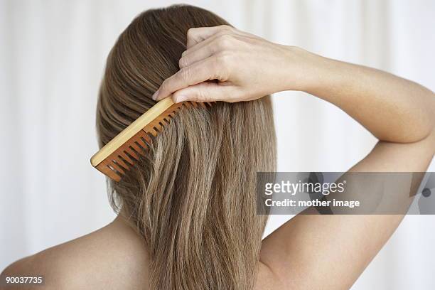 woman combing hair - haarpflege stock-fotos und bilder