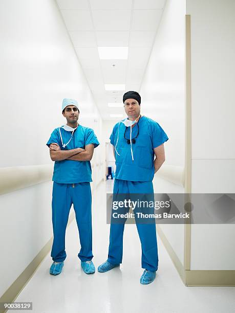 portrait of surgeons in hospital hallway - breitbeinig stock-fotos und bilder