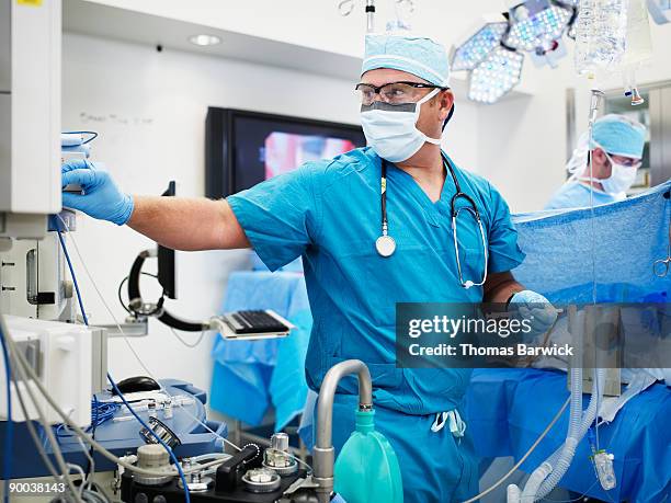 anesthesiologist adjusting anesthesia machine - anesthetist stock pictures, royalty-free photos & images