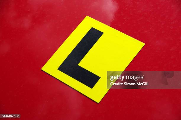 l plate magnetic label on a red car hood - learner driver stock-fotos und bilder