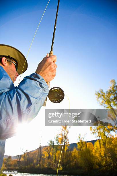 male fly fisherman with fishing rod on river. - carbondale colorado bildbanksfoton och bilder