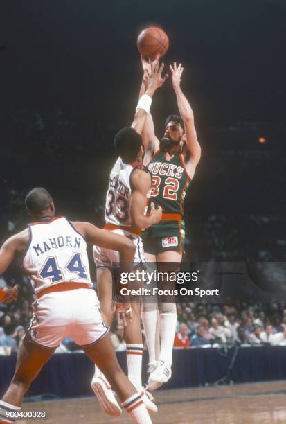 Brian Winters of the Milwaukee Bucks shoots the ball over Andre McCarter of the Washington Bullets during an NBA basketball game circa 1980 at the...