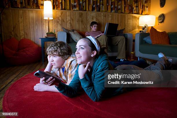 teens watching tv in rec room - boy at television stockfoto's en -beelden