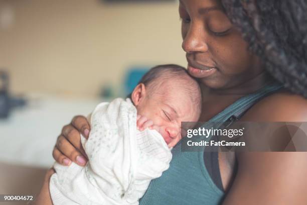 nueva mamá explotación infantil hija - black mother holding newborn fotografías e imágenes de stock