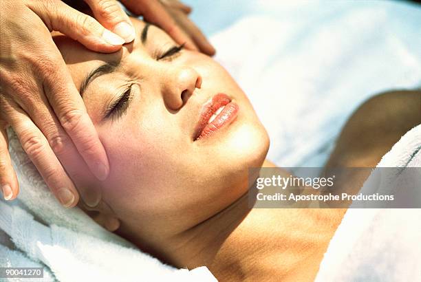 young woman getting facial massage - apostrophe stock pictures, royalty-free photos & images
