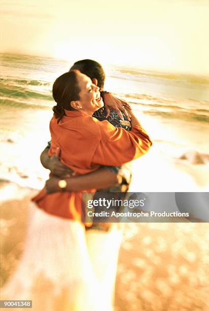 couple hugging on beach - apostrophe stock pictures, royalty-free photos & images