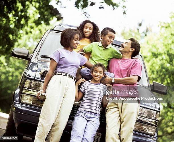 family standing in front of their automobile - apostrophe stock pictures, royalty-free photos & images